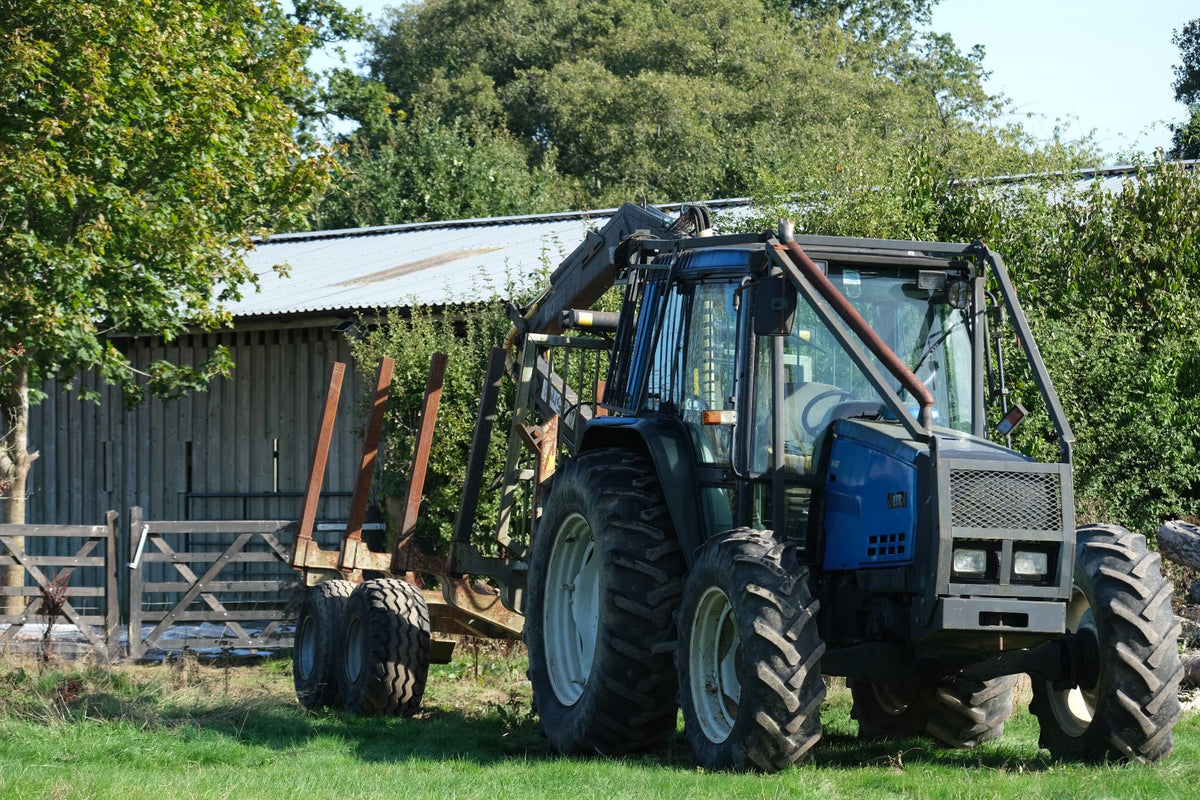 The tractor and timber trailer by the barn